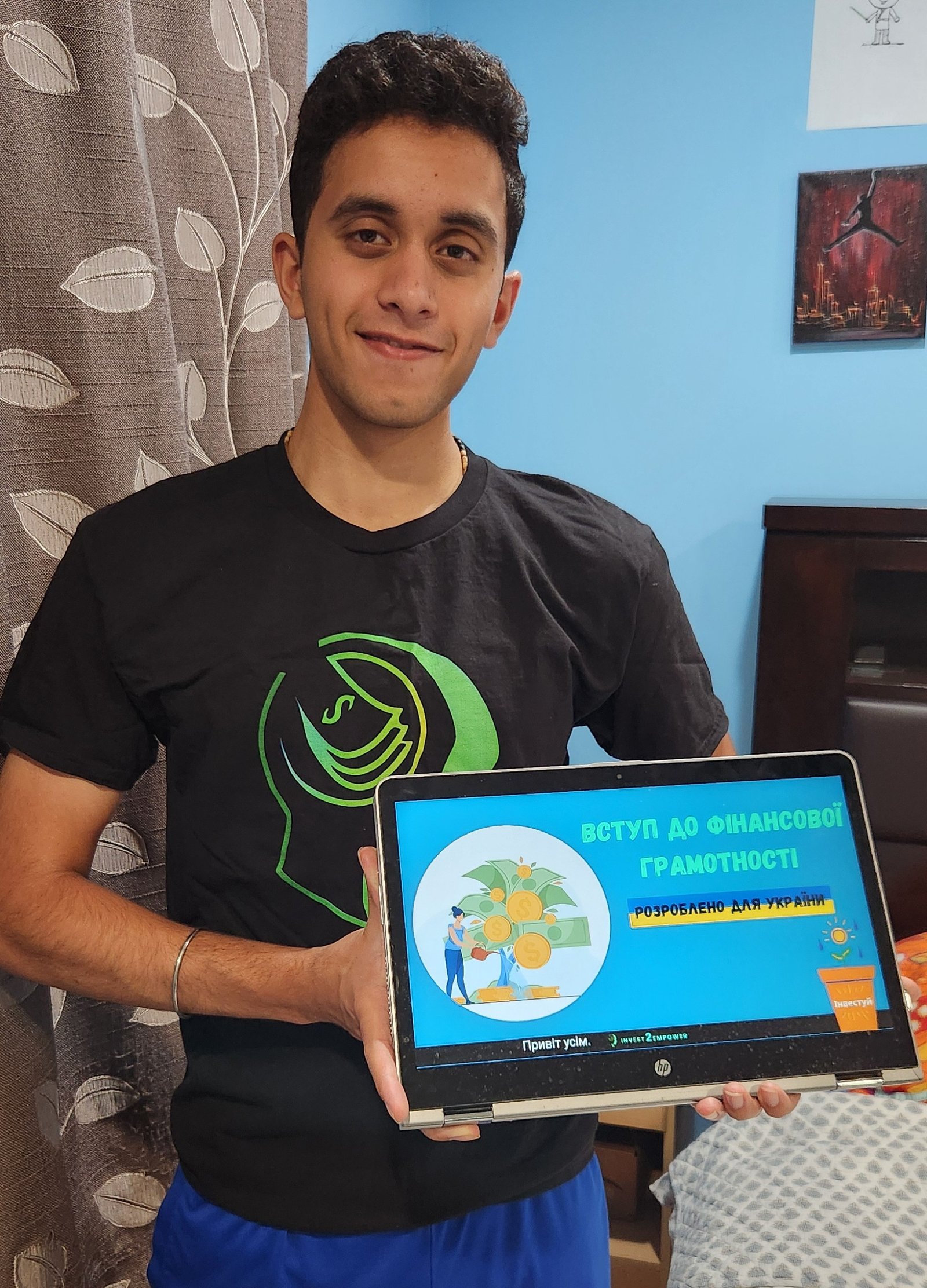 Aditya Herekar holding an Invest2Empower financial-literacy lesson built for Ukraine